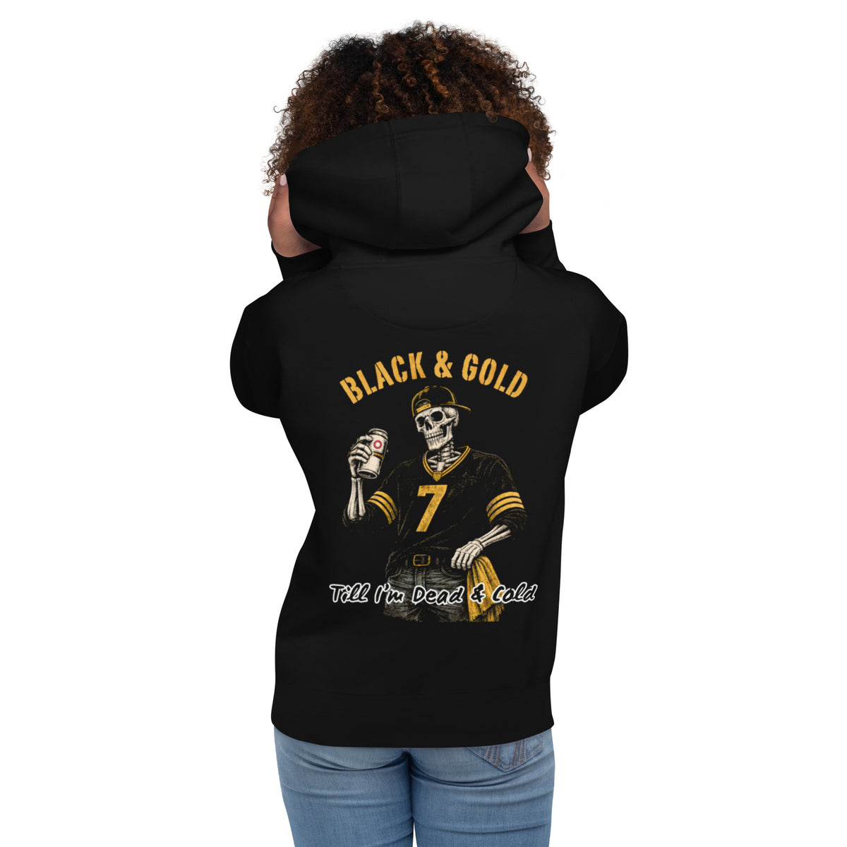 Woman wearing a hoodie. Black & Gold Till I'm Dead & Cold printed on a Black Hoodie with a Skeleton wearing a hat, number 7 Pittsburgh Football Jersey, jeans, with a gold towel in his pocket, and a beer in his hand.