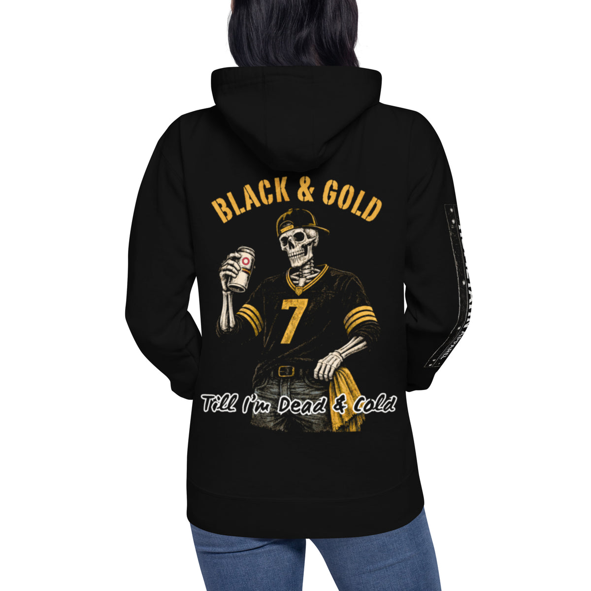 Woman wearing a hoodie. Black & Gold Till I'm Dead & Cold printed on a Black Hoodie with a Skeleton wearing a hat, number 7 Pittsburgh Football Jersey, jeans, with a gold towel in his pocket, and a beer in his hand.