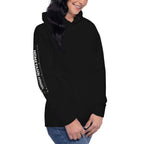 Woman wearing a black hoodie. shown from an angle with HOMETAHN APPAREL down the sleeve.
