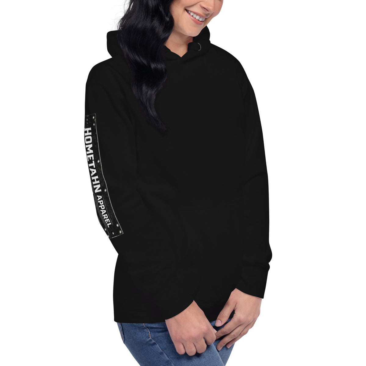 Woman wearing a black hoodie. shown from an angle with HOMETAHN APPAREL down the sleeve.