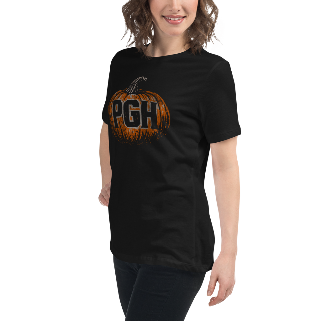 A woman wearing a black short-sleeve t-shirt with a graphic of an orange pumpkin featuring the letters 'PGH' in black.