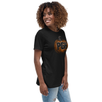 A woman with curly brown hair wearing a black short-sleeve t-shirt with a graphic of a pumpkin containing the letters 'PGH', an abbreviation for Pittsburgh, in black.