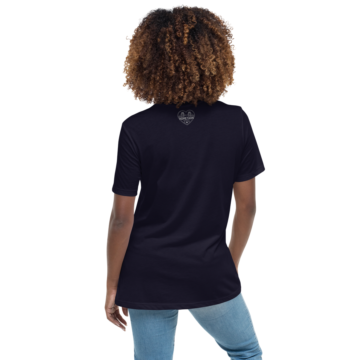 Person wearing a navy blue t-shirt with a logo on the back, standing against a white background